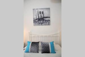- une chambre avec un lit blanc et des oreillers bleus dans l'établissement PDL Central Apartments - Three, à Ponta Delgada
