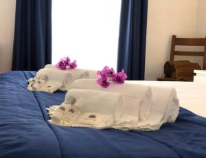 two towels on a bed with purple flowers on them at PDL Central Apartments - Three in Ponta Delgada