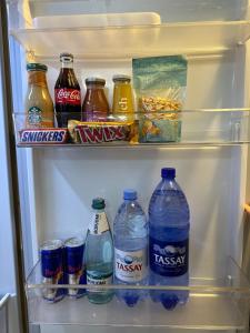 an open refrigerator filled with drinks and soda at DOWNTOWN APPARTMENTS in Karagandy