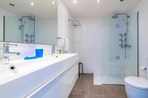 a white bathroom with a sink and a shower at Silver Sands Penthouse in Protaras