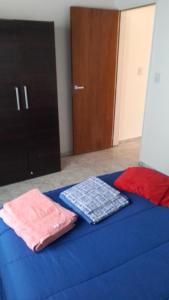 a bed with blue sheets and folded towels on it at Sendero Patagonico in Las Grutas