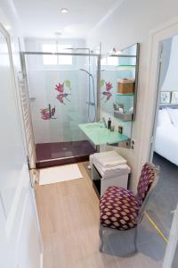 ein Badezimmer mit Dusche, Stuhl und Waschbecken in der Unterkunft La Maison Jules in Tours