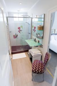 a bathroom with a shower and a chair and a sink at La Maison Jules in Tours