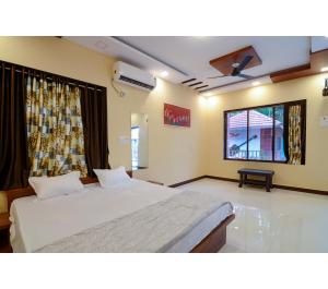sypialnia z dużym łóżkiem i oknem w obiekcie Bhumi Cottage w mieście Revadanda