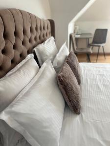 Un dormitorio con una cama con almohadas blancas. en Central Studio 28, en Sinaia