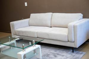 biała kanapa i dwa stoły w salonie w obiekcie Urban Oasis Apartments at Freedom Plaza w mieście Windhuk