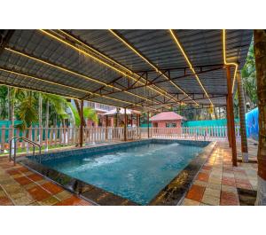 a large swimming pool under a large umbrella at Bhumi Cottage in Revadanda