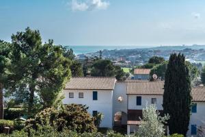 een wit huis met bomen op de voorgrond bij N116 - Numana, quadrilocale con vista mare in Numana