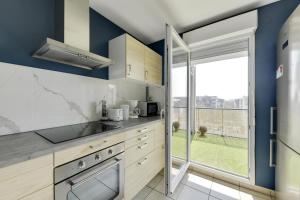 a kitchen with blue walls and a large window at Chic apartment with superb view of the eiffel tower in Saint-Denis +26 photos