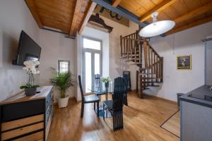 a living room with a table and a staircase at Lungarno Buozzi 7 Apartments in Pisa