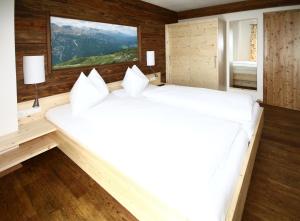 a large white bed in a room with wooden walls at Hotel Zum Granitzl in Mariapfarr