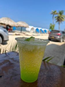 una copa sentada en una mesa junto a la playa en El Mejor Lugar para descansar cabaña OASIS, en San Antero