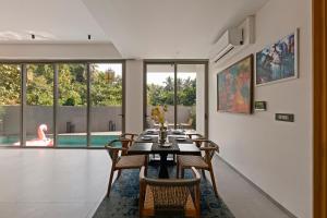 a dining room with a table and chairs and a pool at The Banyan Tree Villa B1 by Stay ALYF, Siolim in Siolim