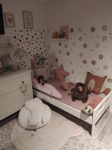 ein Kinderschlafzimmer mit einem Bett mit ausgestopften Tieren in der Unterkunft Home Apartman in Nagyesztergár