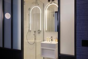 La salle de bains est pourvue d'un lavabo et d'une douche. dans l'établissement Best Western Bretagne Montparnasse, à Paris
