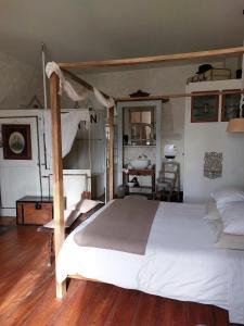 sypialnia z białym łóżkiem i drewnianą podłogą w obiekcie Au Bonheur d'Alphonse w mieście Lusignan-Petit