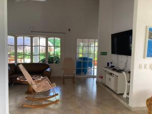 sala de estar con sofá y TV en El Mejor Lugar para descansar cabaña OASIS, en San Antero