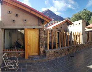 a building with a wooden door and a fence at Villa Narcisa in Purmamarca