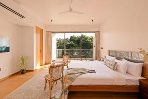 a bedroom with a large bed and a large window at The Banyan Tree Villa B1 by Stay ALYF, Siolim in Siolim