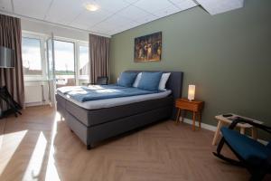 a bedroom with a bed with blue pillows on it at Hotel Workum in Workum