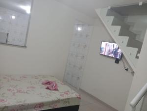 a room with a bed and a stair case at Netinho in Aparecida