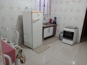 a small kitchen with a refrigerator and a stove at Netinho in Aparecida