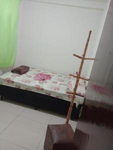 a small bed in a room with a chair at Netinho in Aparecida +1 photo