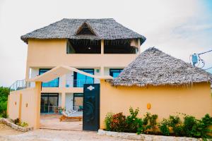 a large house with a thatched roof at Cappadocia Hotel in Nungwi