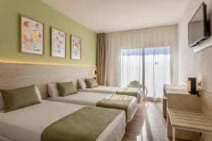 um quarto de hotel com duas camas e uma televisão em Hotel Jaime I em Salou