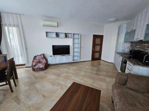 a living room with a couch and a flat screen tv at Elegantz Apartments 2 in Varna City