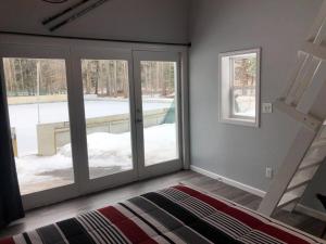 a bedroom with sliding glass doors and a bed at Hockey Themed Room with Wooded Trails in Benzonia