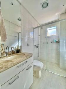 une salle de bain avec un lavabo, des toilettes et une douche dans l'établissement Apt bem localizado centro praia box WiFi ar-condicionar, à Capão da Canoa