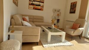 a living room with a couch and a table at MINA modern & cozy apartment main city square GTC Skopje in Skopje