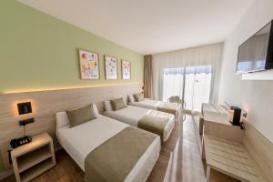 a hotel room with two beds and a flat screen tv at Hotel Jaime I in Salou