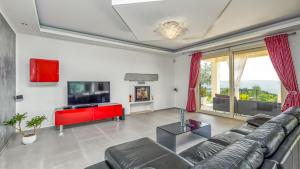 - un salon avec un canapé et une télévision dans l'établissement Villa Over The Hilltop, à Bencani