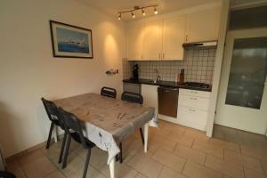 een keuken met een tafel en stoelen in een kamer bij Schorrebloem 20* in Nieuwvliet