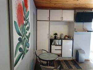 Bloemfontein的住宿－Chic Breeze，小厨房配有玻璃桌和桌椅