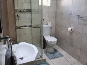 a bathroom with a toilet and a shower and a sink at Chic Breeze in Bloemfontein