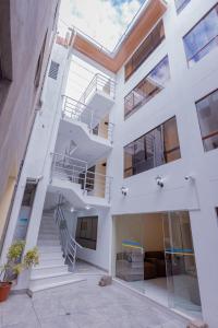 un gran edificio blanco con escaleras y escalera en Cusco hawka inka hostal en Cusco