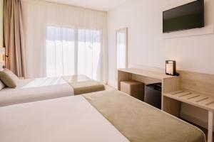 a hotel room with two beds and a television at Hotel Jaime I in Salou