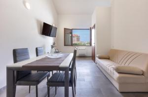 un soggiorno con tavolo e divano di Al civico 5 - Mondern Apartments & Suite! a Decimomannu