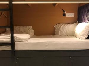 two bunk beds with white pillows in a room at Stayvilla Hostel in Mumbai
