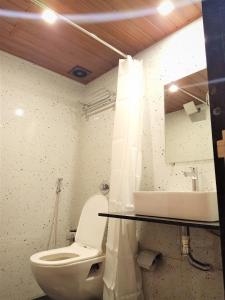 a bathroom with a toilet and a sink and a mirror at Stayvilla Hostel in Mumbai