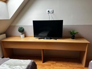 a desk with a television on top of it at Gyarmati Panzió & Étterem in Veszprém