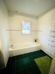uma casa de banho com uma banheira e uma janela em Ty Traezh - La plage à 100m em Santec