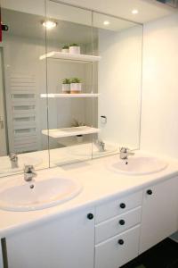 uma casa de banho com 2 lavatórios e um espelho em Ty Traezh - La plage à 100m em Santec
