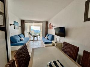 sala de estar con sofá azul y mesa en Les Restanques 4027 vue mer grande terrasse en Grimaud