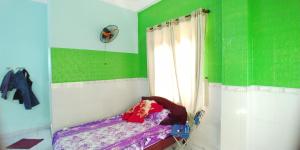 a bedroom with green and white walls and a bed at Hostel Loc Quyen in Da Nang