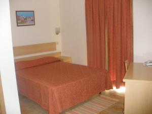 a small bedroom with a bed and orange curtains at Dom Fernando II in Loulé