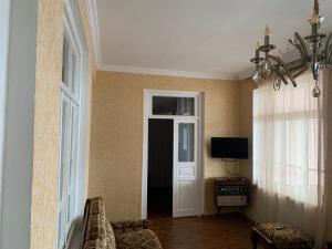 Habitación con puerta, TV y ventana en Villa Bodbe en Sighnaghi